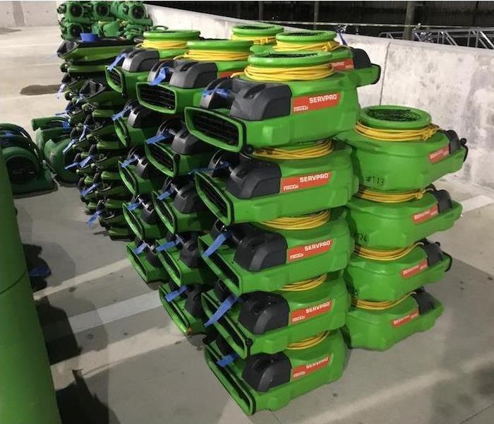Stacks of green air movers, back of a truck, in parking garage staging area
