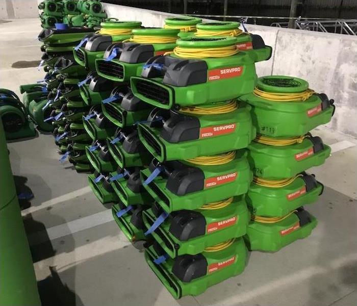 SERVPRO green air movers stacked in a parking lot
