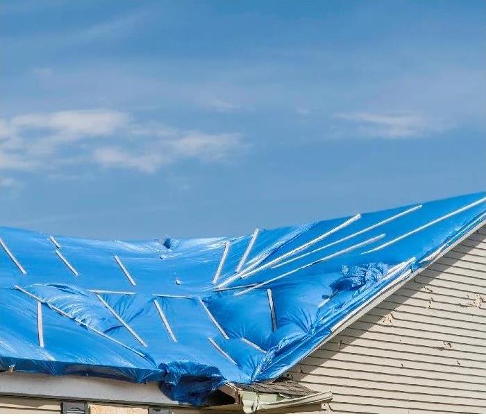 Blue tarp covering storm damaged roof