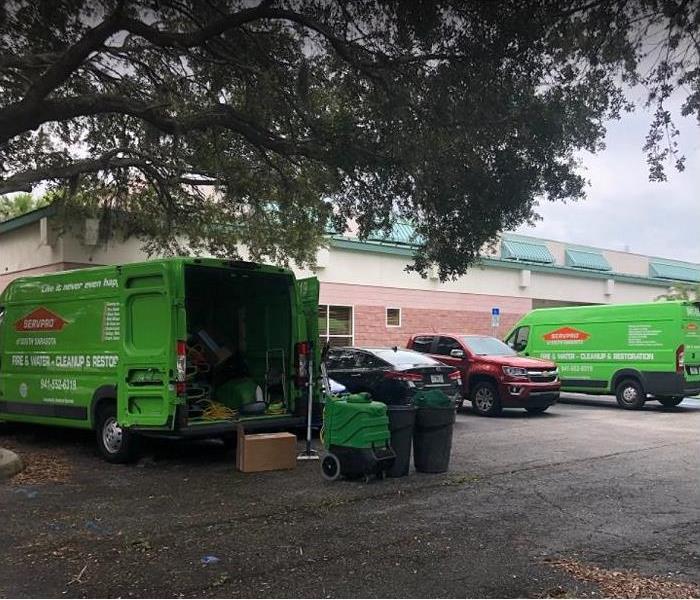 SERVPRO van parked outside of commercial building; back opened showing equipment