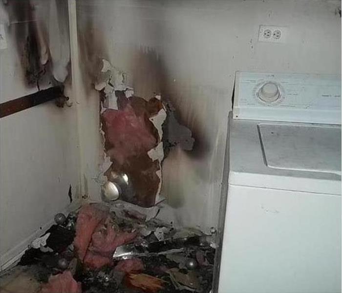 A clothes dryer in a laundry room that caught fire from a clogged vent