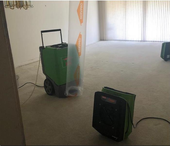 SERVPRO restoration equipment being used in water damaged room.