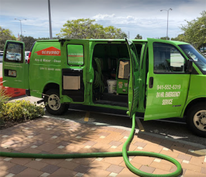 SERVPRO van with hose to suction water extending from the van